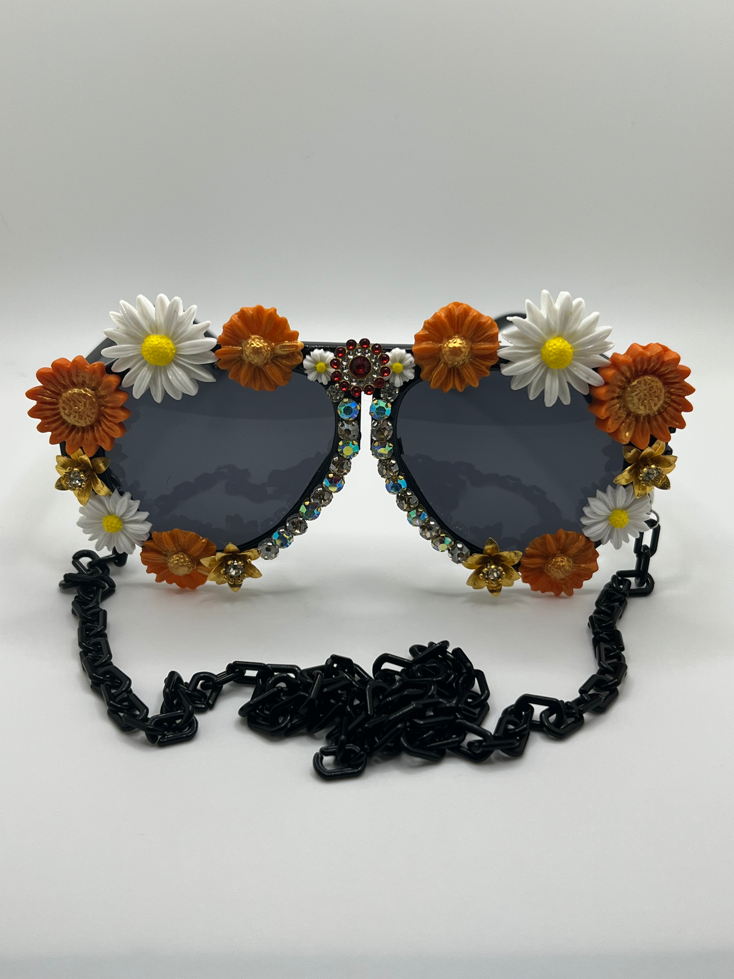 Perfect for tailgating and supporting your Longhorns, these oversized aviators are surrounded by handmaid, burnt orange and white florals and shimmering rhinestones.