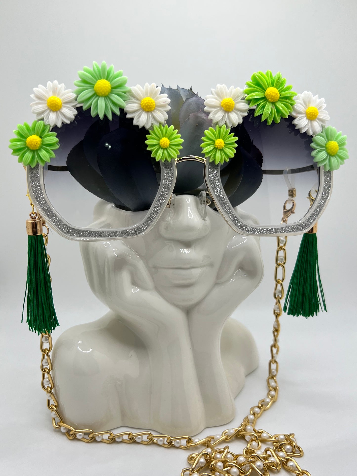 Bright daisies surround these sparkling silver octagon sunglasses and are accompanied by an adjustable and removable eyewear chain and removable, oversized tassels.