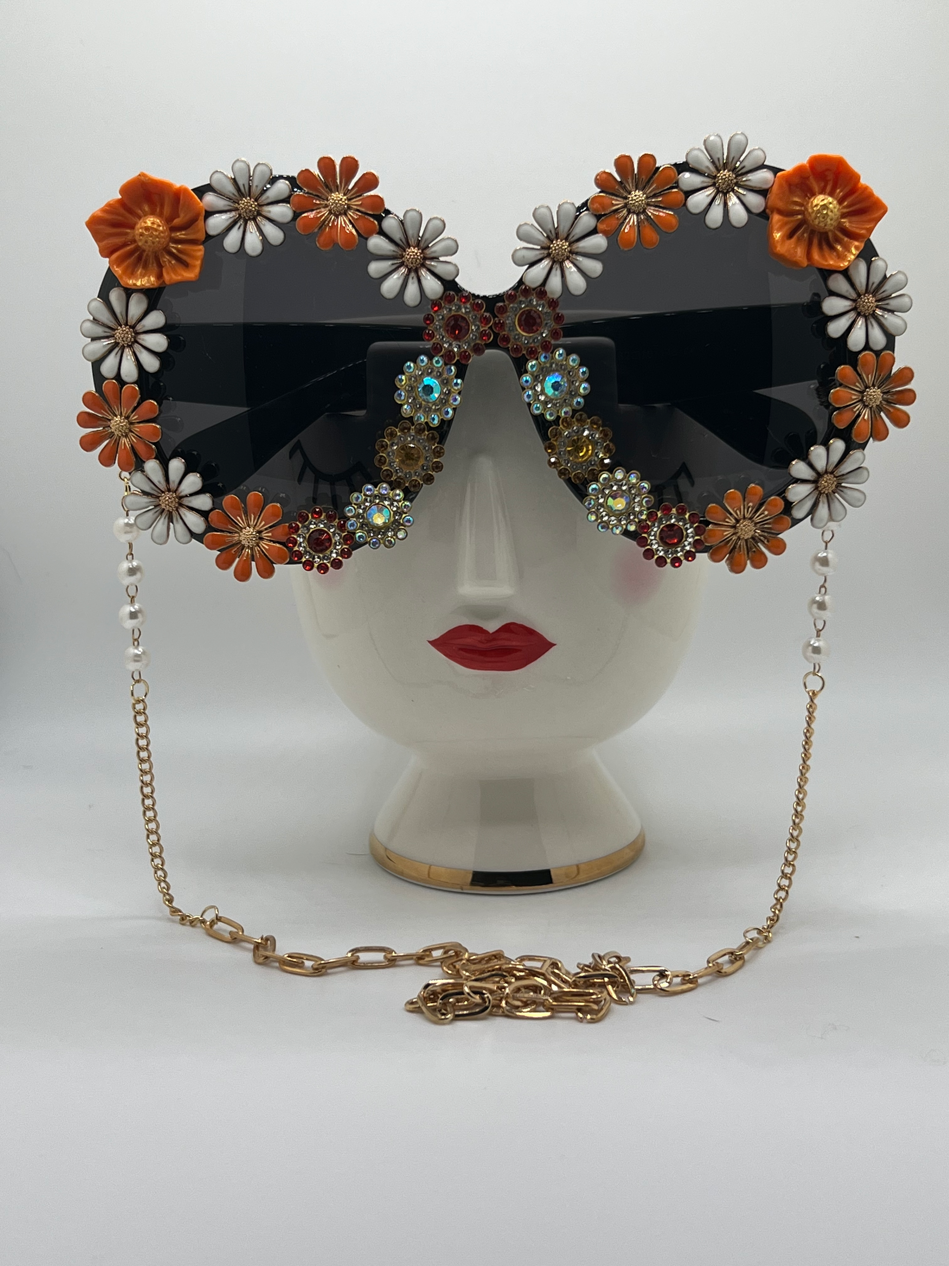 Perfect for tailgating and supporting your Longhorns, these round, oversized sunglasses are covered in floral and jeweled embellishments and come with a removable chain.