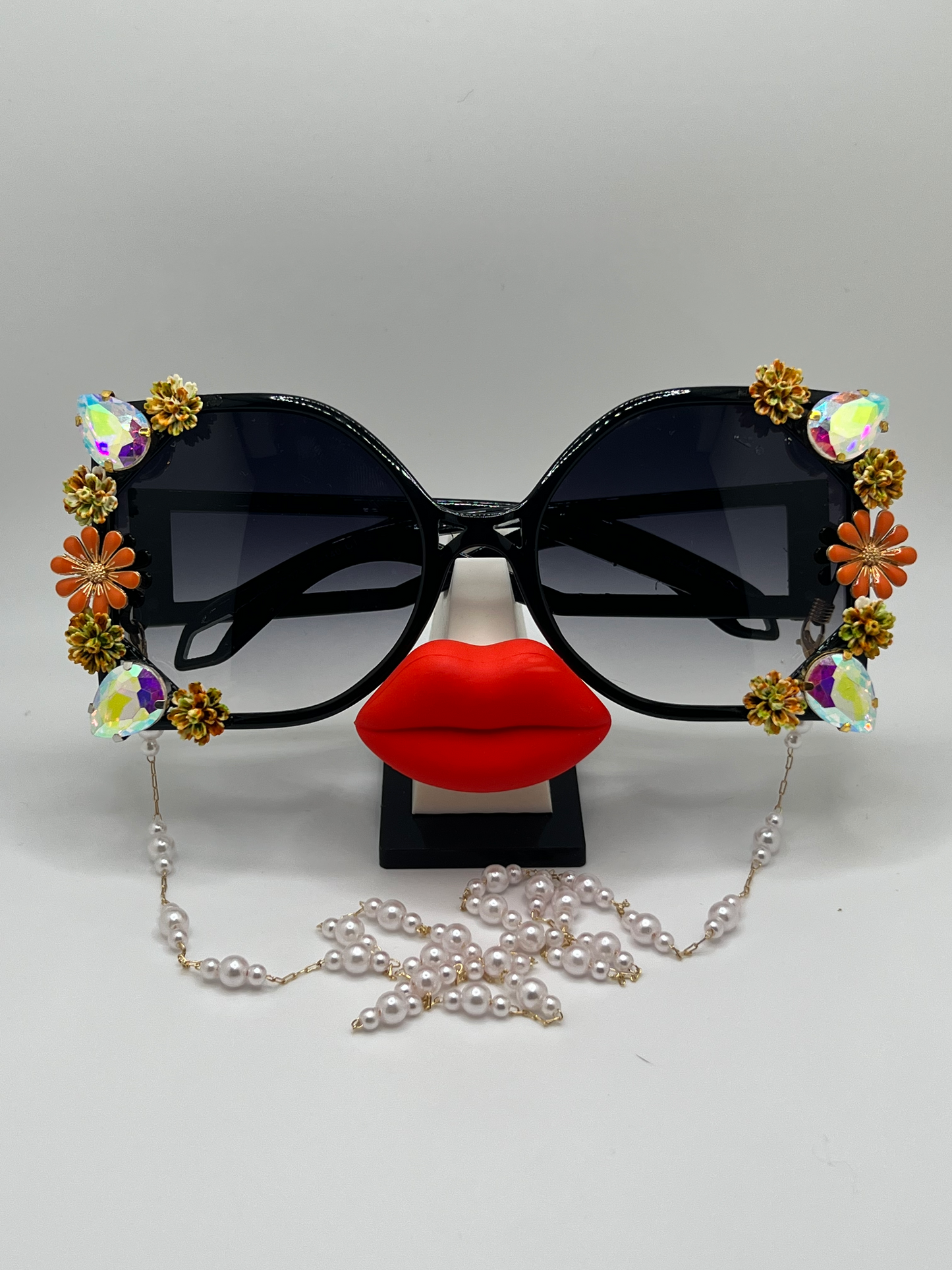 Perfect for tailgating and supporting your Longhorns, these Square-sided, oversized sunglasses are covered in floral and jeweled embellishments and come with a removable chain.